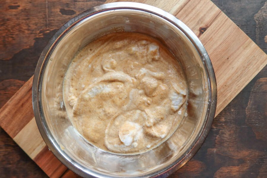 Pumpkin spice pancake batter in a stainless steel bowl.