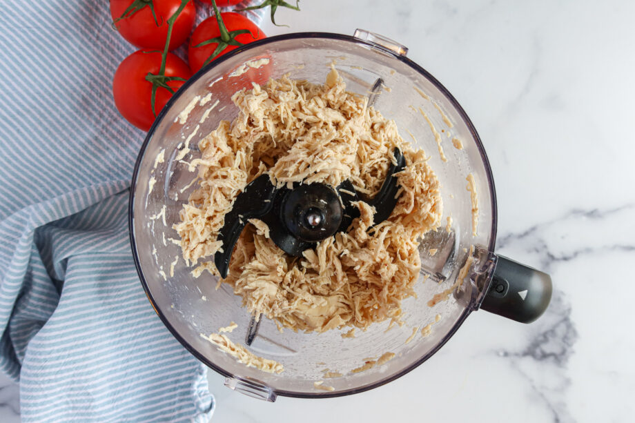 Shredded chicken in a food processor.