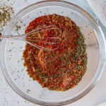 Whisking spices together in a large bowl.