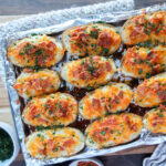 Twice baked potatoes on a foil lined baking sheet.