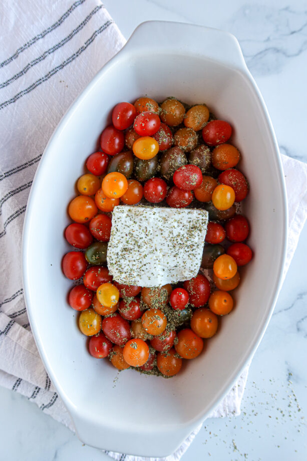 Tomatoes, feta & seasonings in a white baking dish, ready to bake!