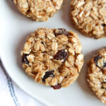 Close up of no-bake vegan oatmeal raisin breakfast cookies on a white plate.