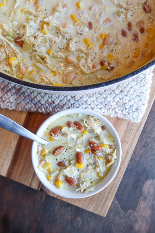 Creamy white chicken chili in a small white bowl with a silver spoon.