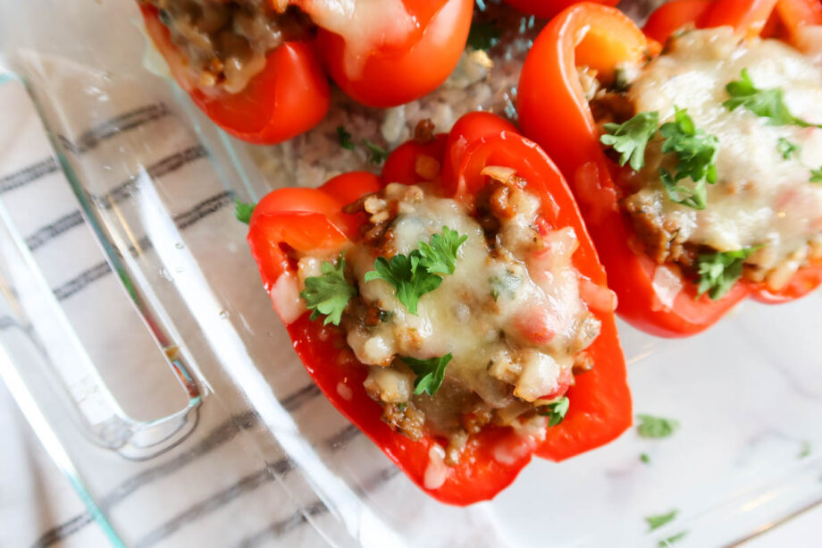 Close up of sausage stuffed peppers in a glass baking dish.