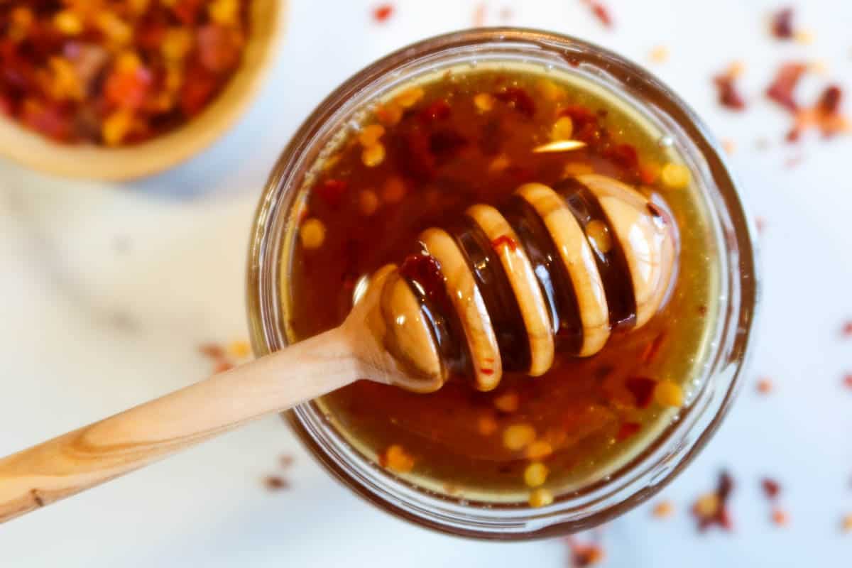 Hot honey in a jar with a honey dripper.