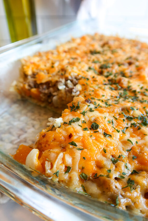 Butternut squash casserole with rice and ground beef in a baking dish.
