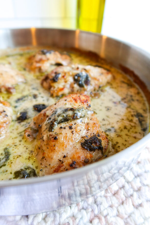 Close up of one skillet chicken thighs with creamy spinach sauce.