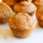 Banana carrot muffins on a white countertop.