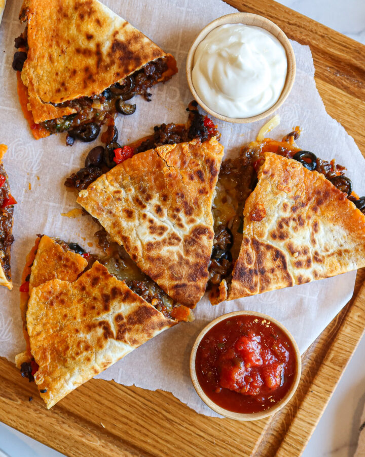 Chorizo quesadillas cut into pieces and arranged on a cutting board.