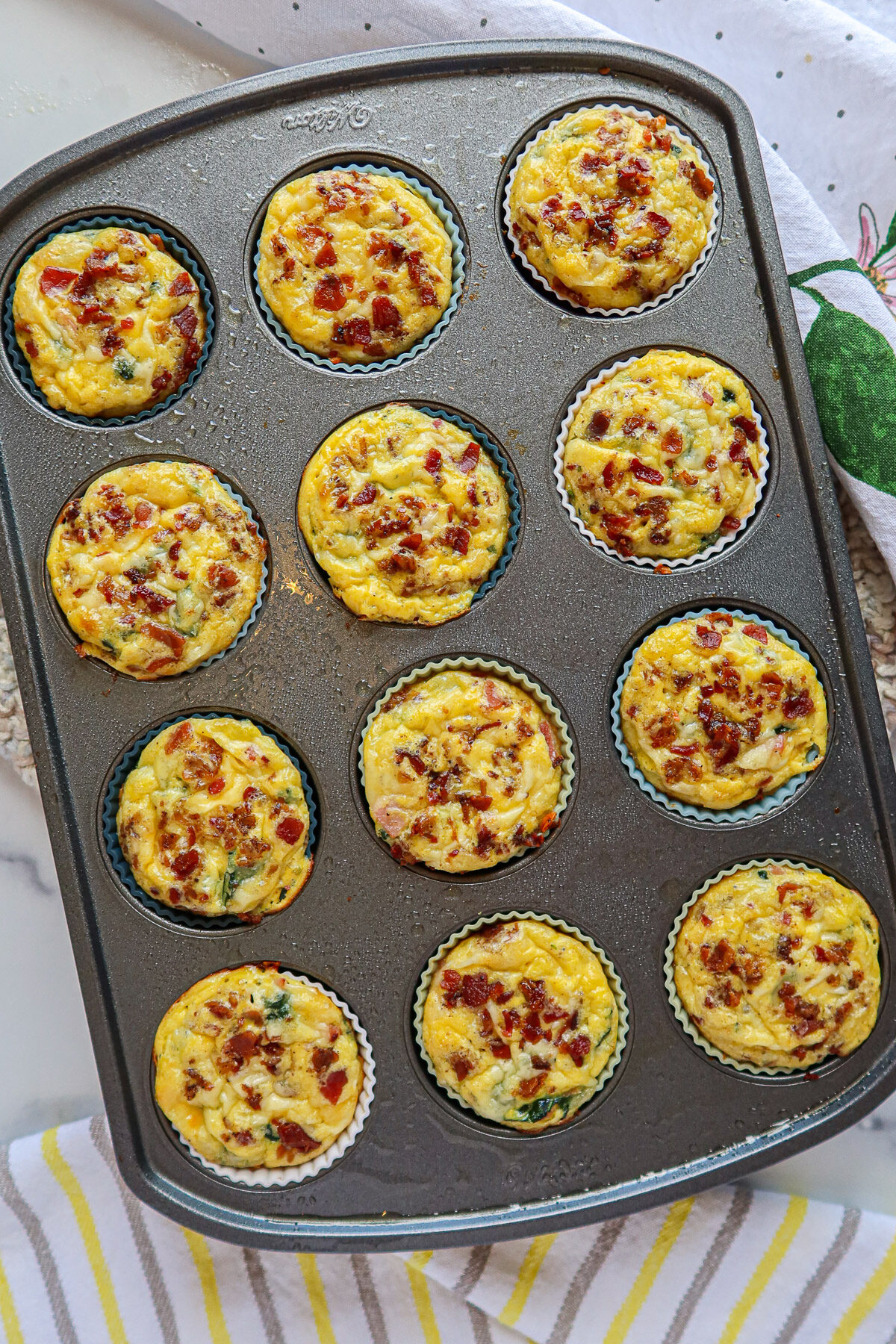 Baked quiche cups in a lined muffin pan.