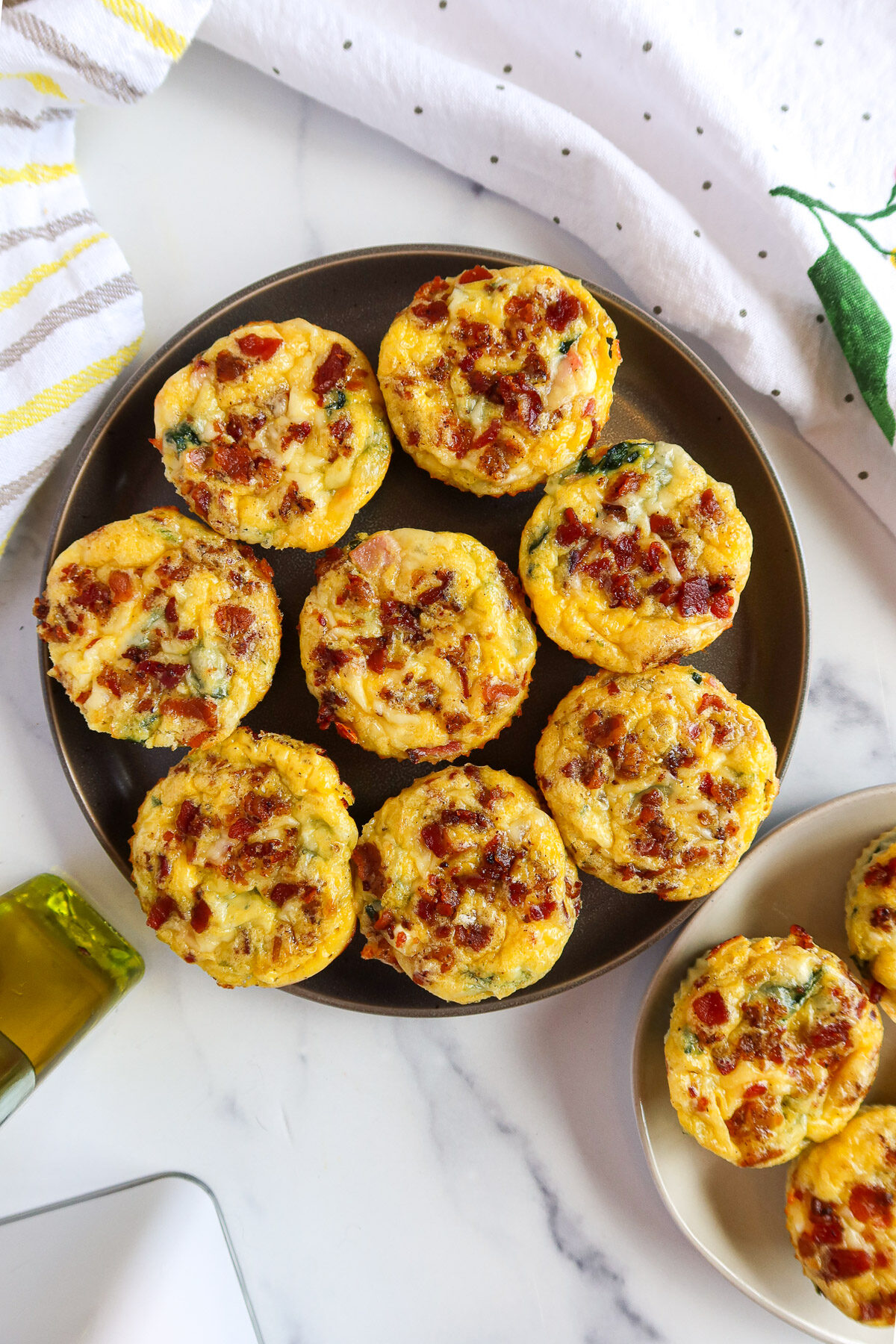 Ham and cheese quiche cups on gray and white plates.