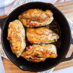 Blue cheese stuffed chicken breasts in a black cast iron skillet.