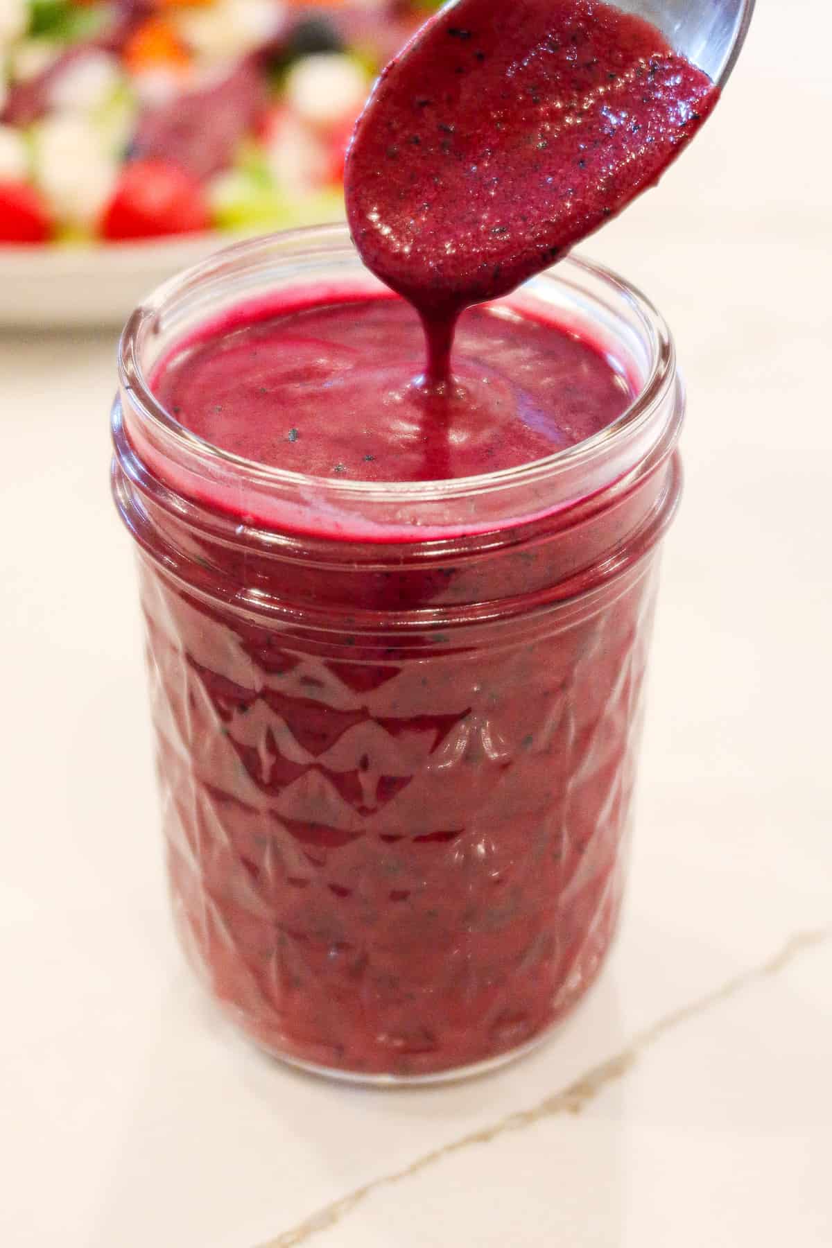 Blueberry vinaigrette salad dressing in a small, glass jar.