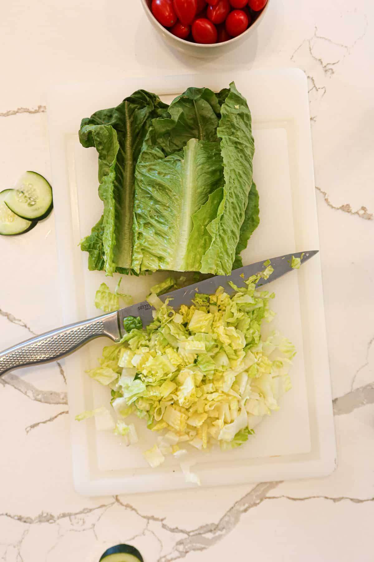 Chopping romaine lettuce on a white cutting board.