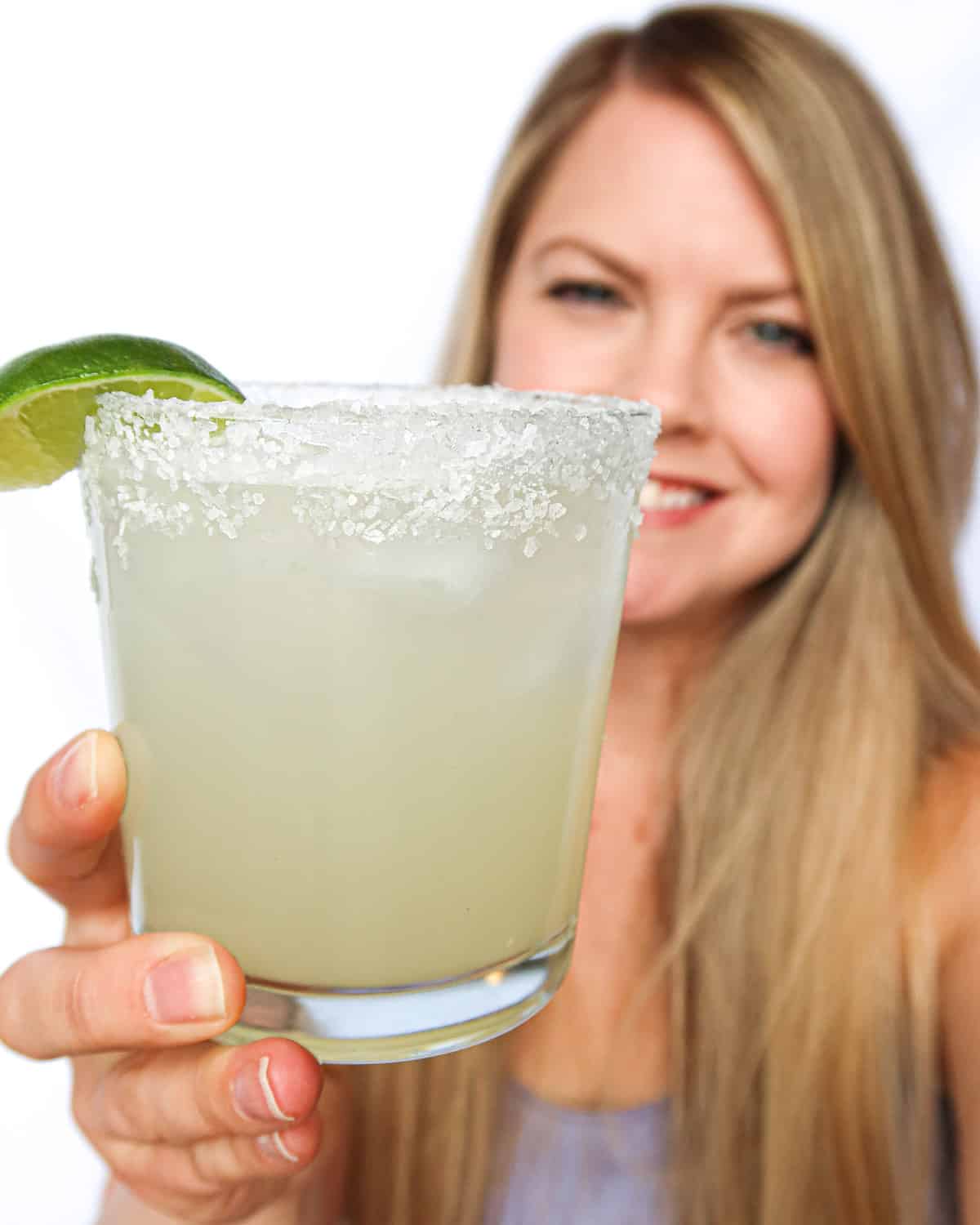 Stacey (the author) holding a margarita and smiling.