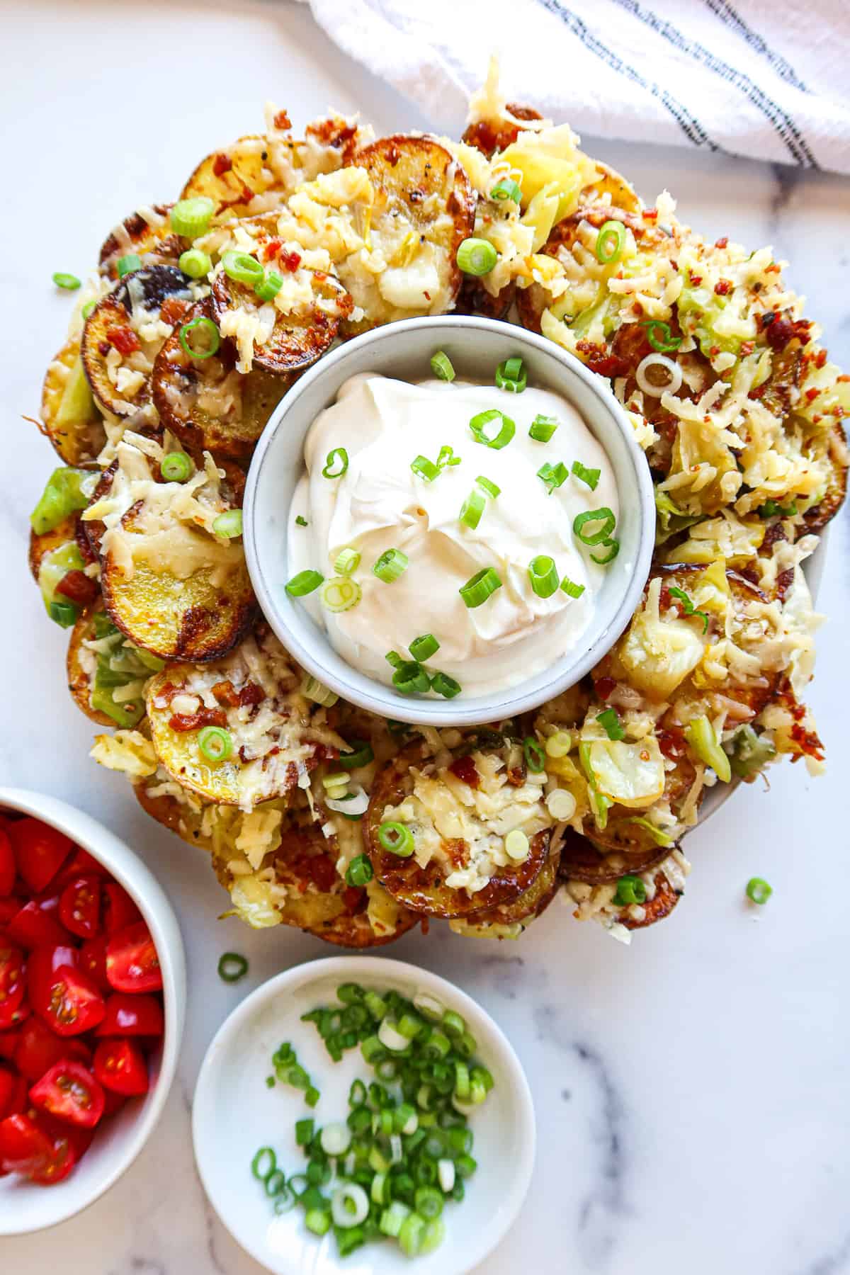 Irish nachos on a serving plate with sour cream for dipping.