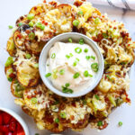 Irish nachos on a serving plate with sour cream for dipping.