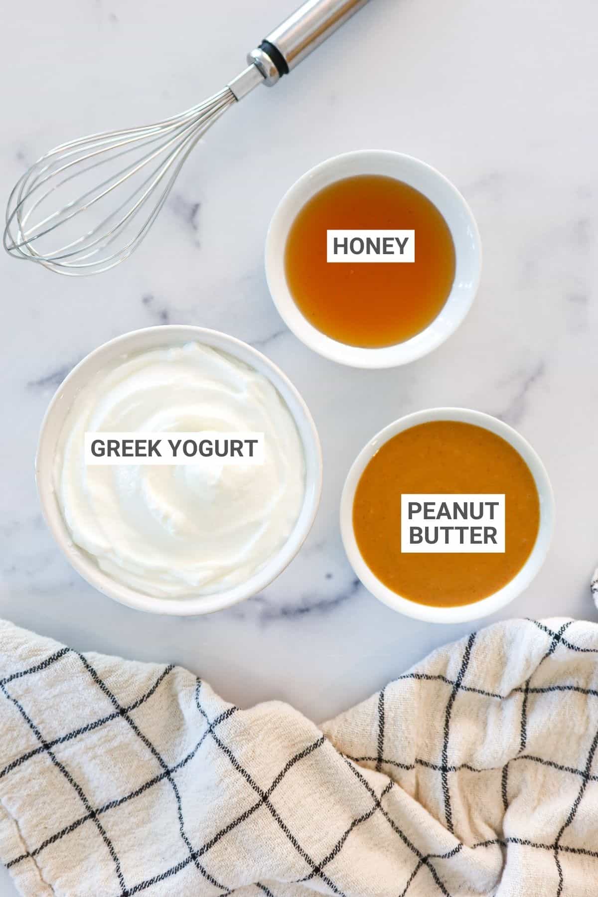 Ingredients for yogurt peanut butter dip arranged on a countertop with text overlay for Pinterest.