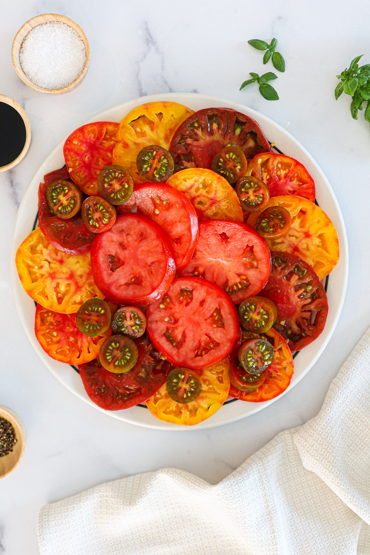 Heirloom tomato slices arranged neatly on a round plate.