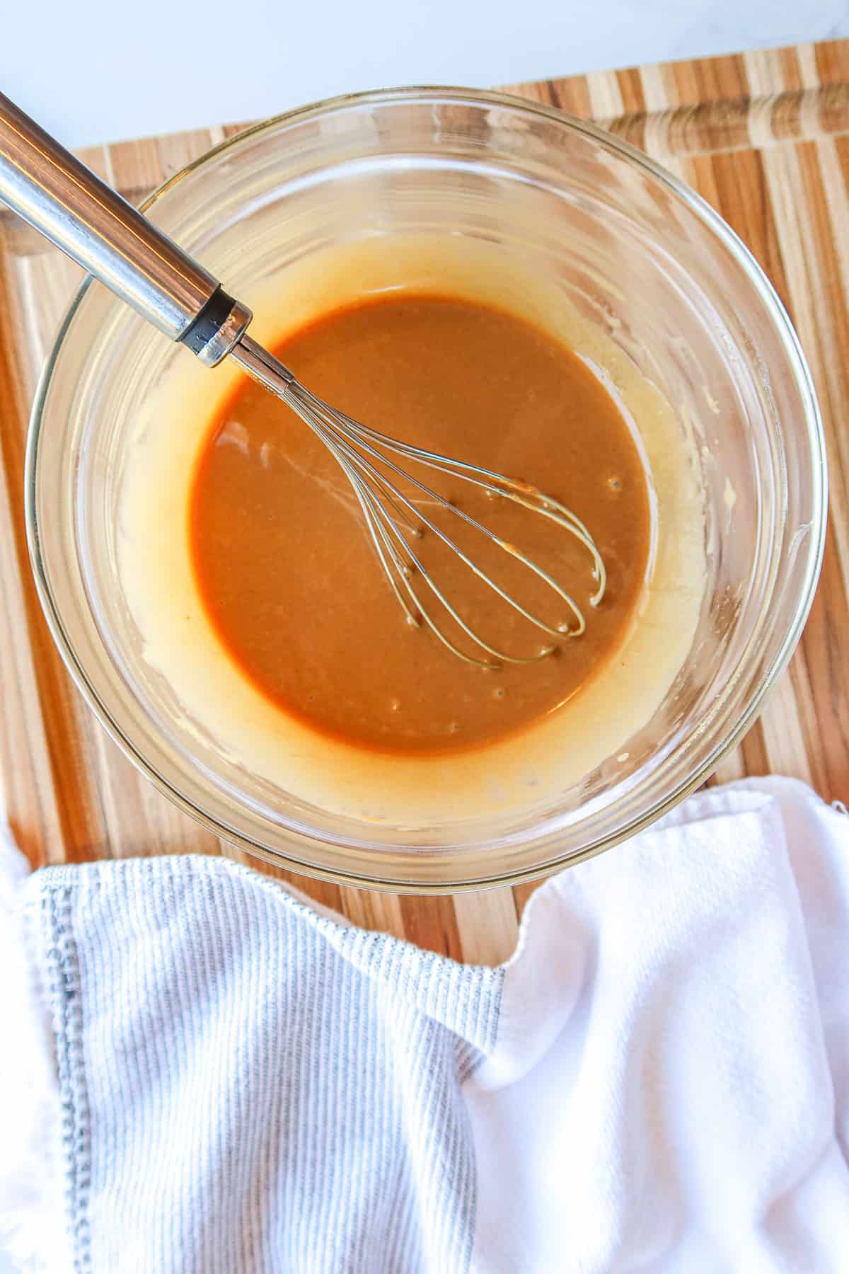 Peanut sauce whisked up in a glass mixing bowl.
