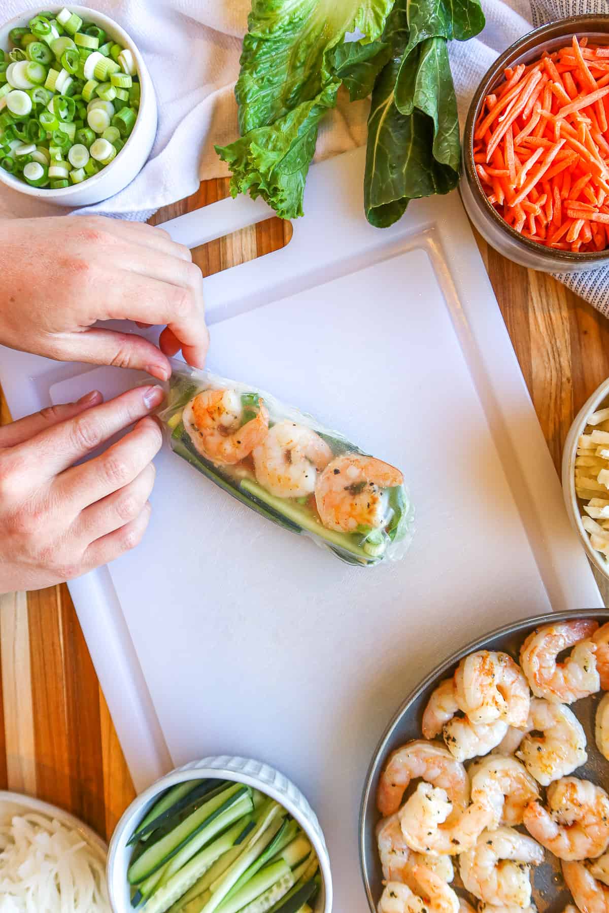 Wrapping softened rice paper around shrimp and vegetables.
