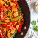 Sweet and spicy chicken stir fry in a black wok.