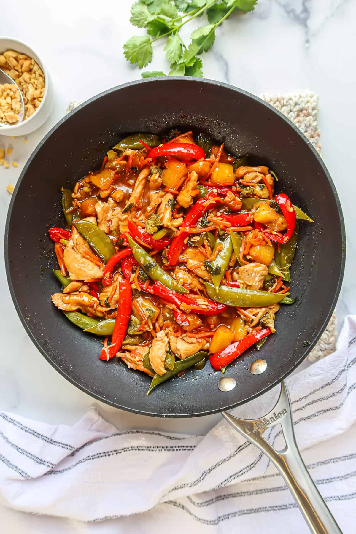 Sweet and spicy chicken stir fry in a black wok.