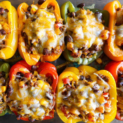 Baked stuffed peppers in a glass baking dish.