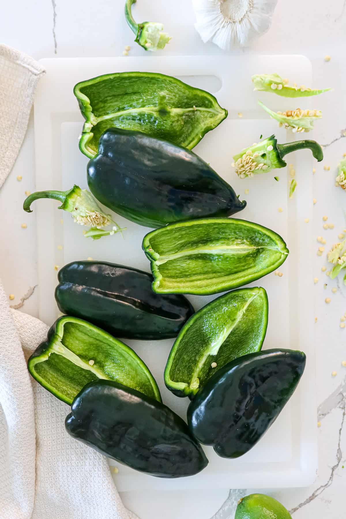 Halved poblano peppers with stems and seeds removed.