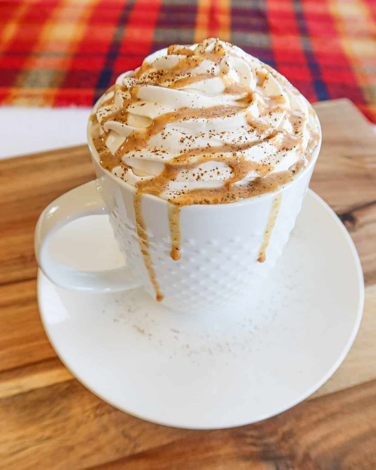 Coffee topped with whipped cream and pumpkin spice sauce drizzle.