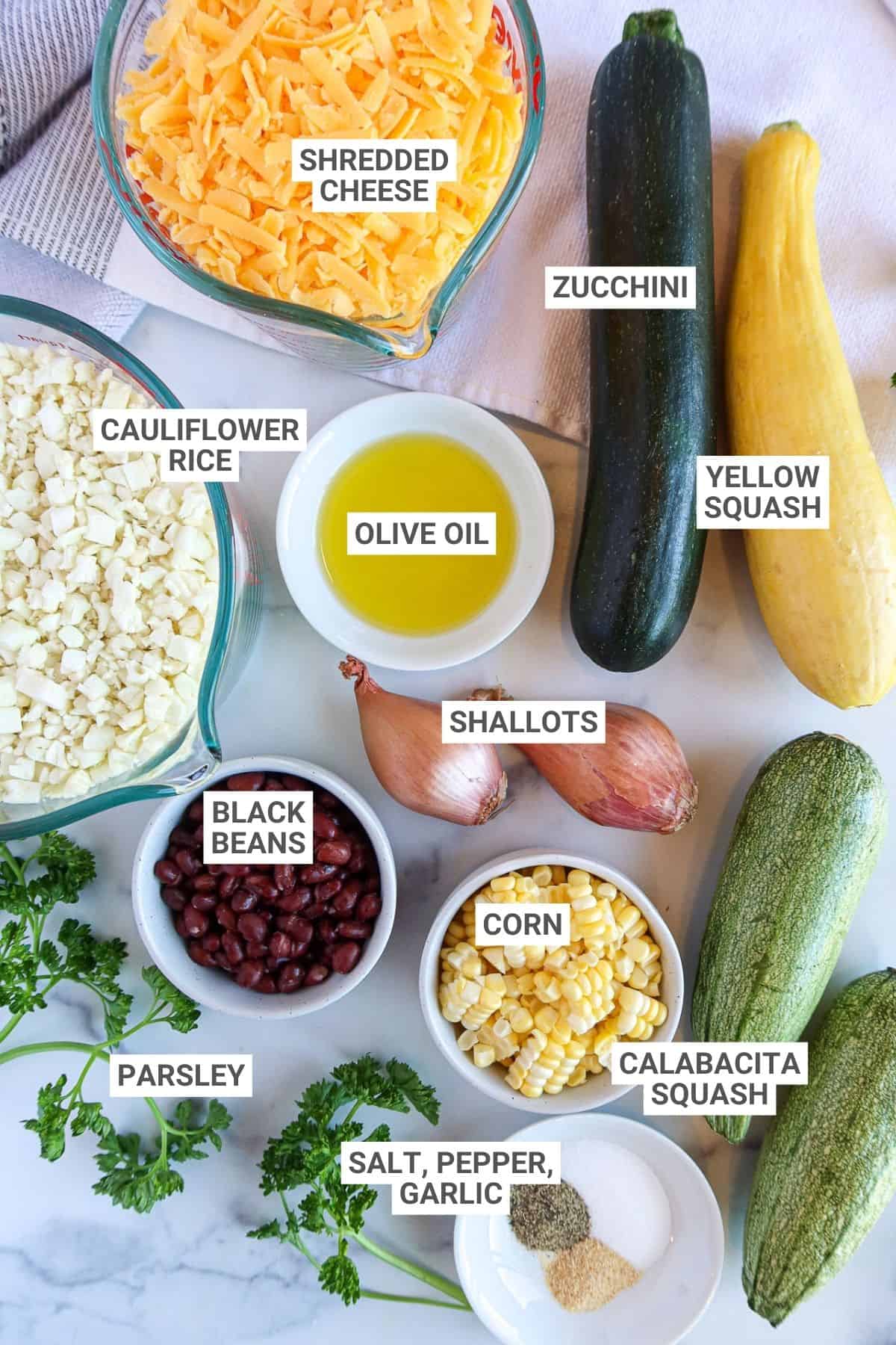 Ingredients for zucchini, squash and corn casserole arranged on a countertop with text overlay labels.