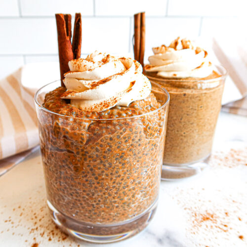 Pumpkin chia pudding in a serving glass with whipped topping.