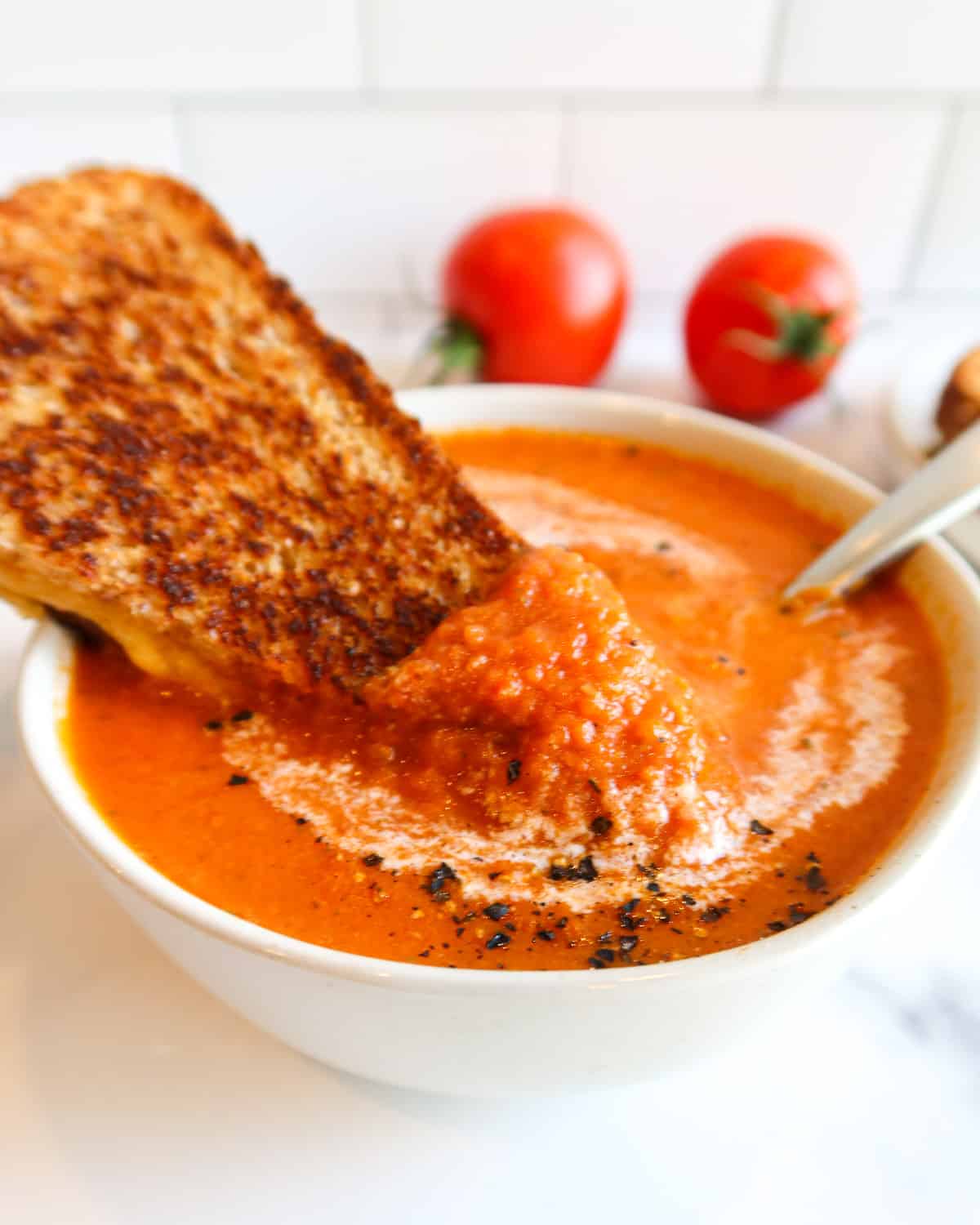 Dipping grilled cheese sandwich in tomato soup.