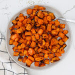 Air fried sweet potato cubes in a white serving bowl.