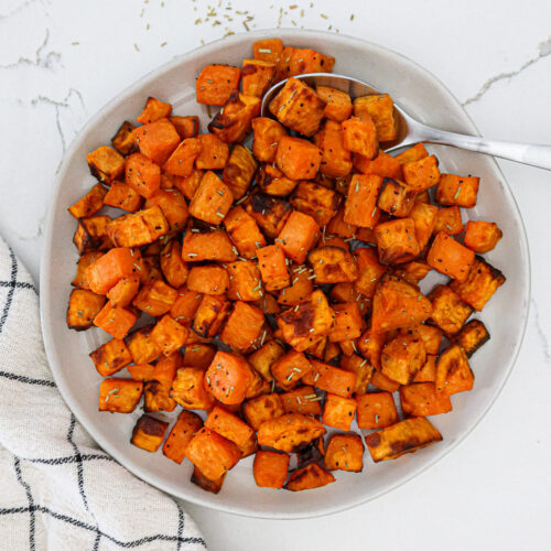 Air fried sweet potato cubes in a white serving bowl.