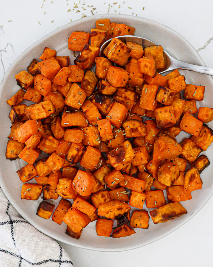 Air fried sweet potato cubes in a white serving bowl.