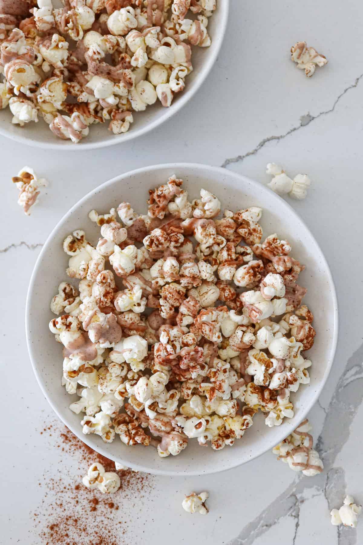 Cinnamon popcorn in small, white serving bowls. 