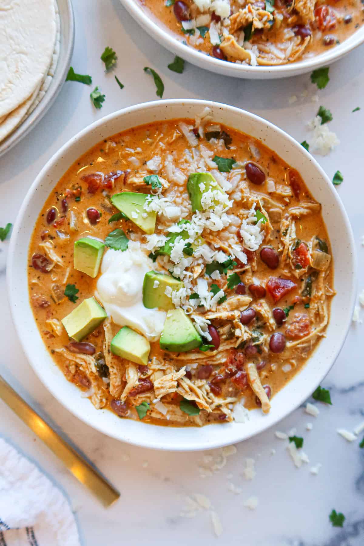 Taco soup with toppings in a white serving bowl.