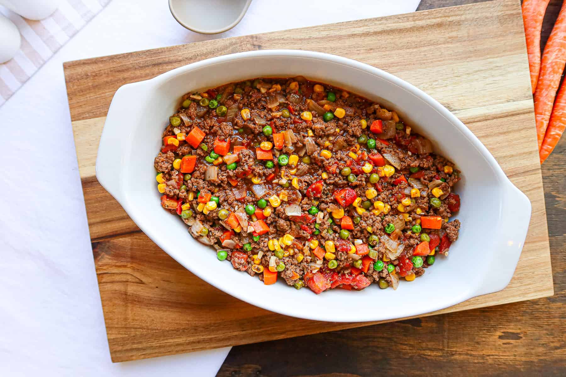 Ground turkey shepherd's pie filling spread evenly in a white baking dish.