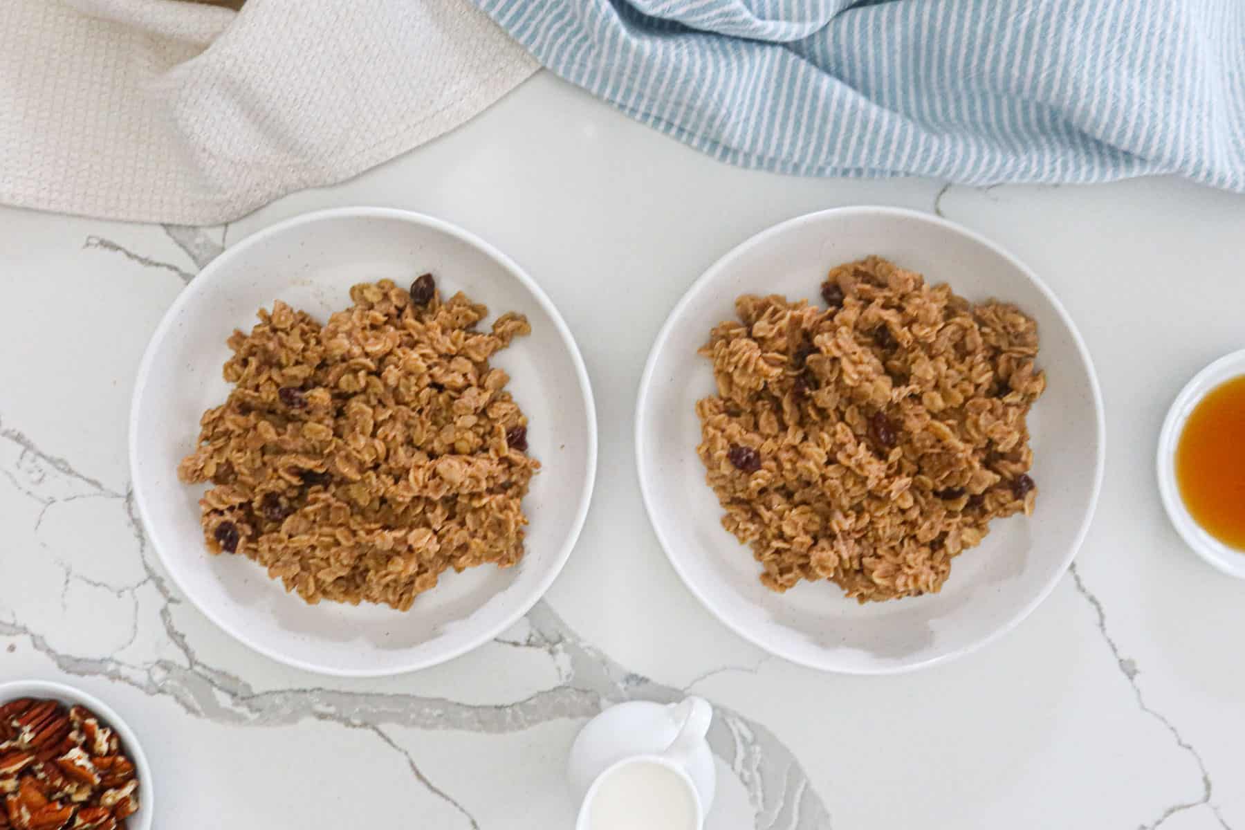 Cinnamon oatmeal divided into two white serving bowls.