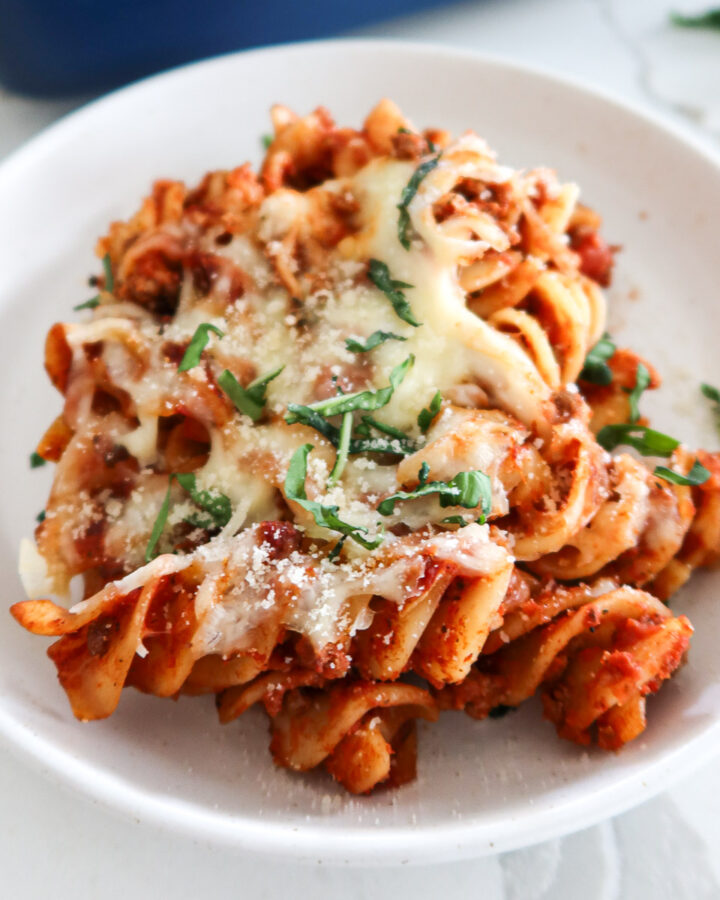 A piece of cheesy ground beef pasta bake on a plate.