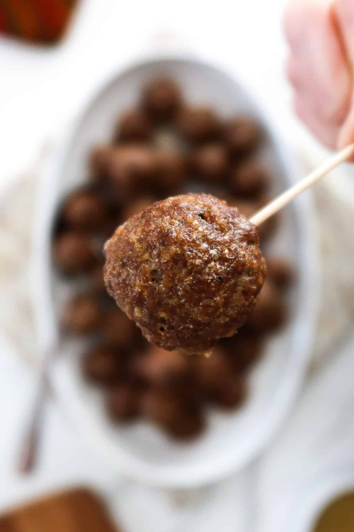 A close-up of a mini meatball on a cocktail toothpick.