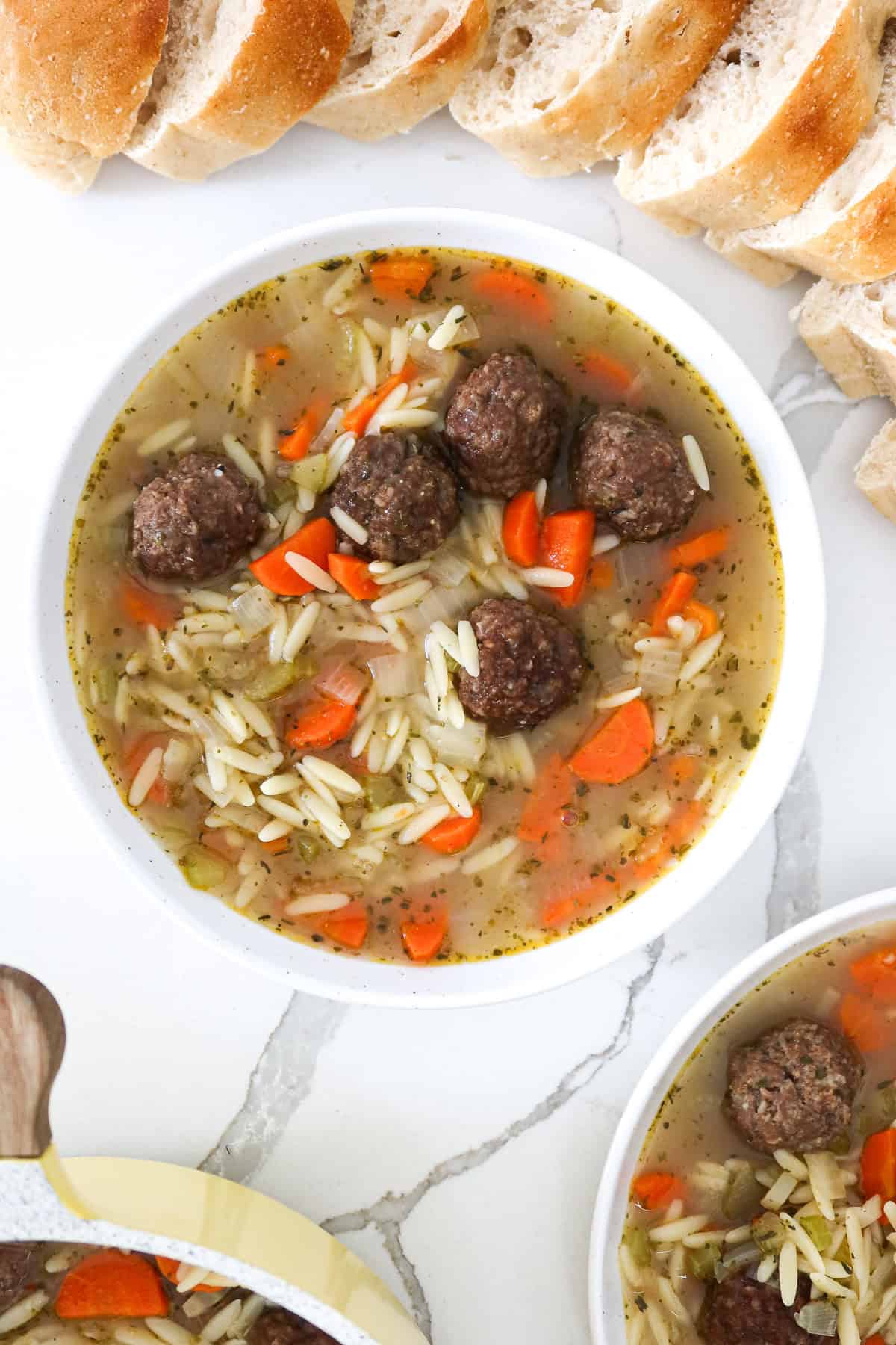 A bowl of meatball orzo soup.