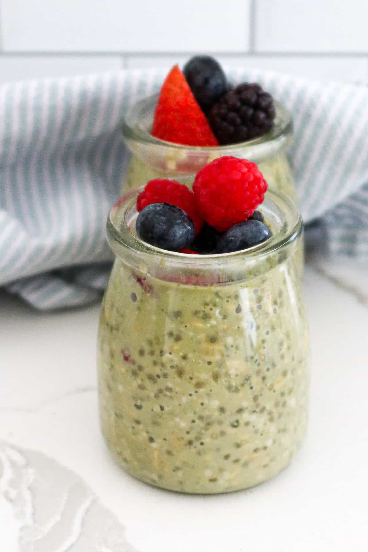 Matcha overnight oats with berries on top.