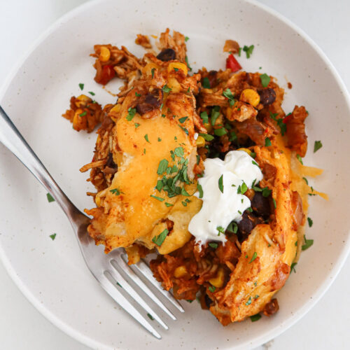 Piece of crockpot chicken enchilada casserole on a plate.