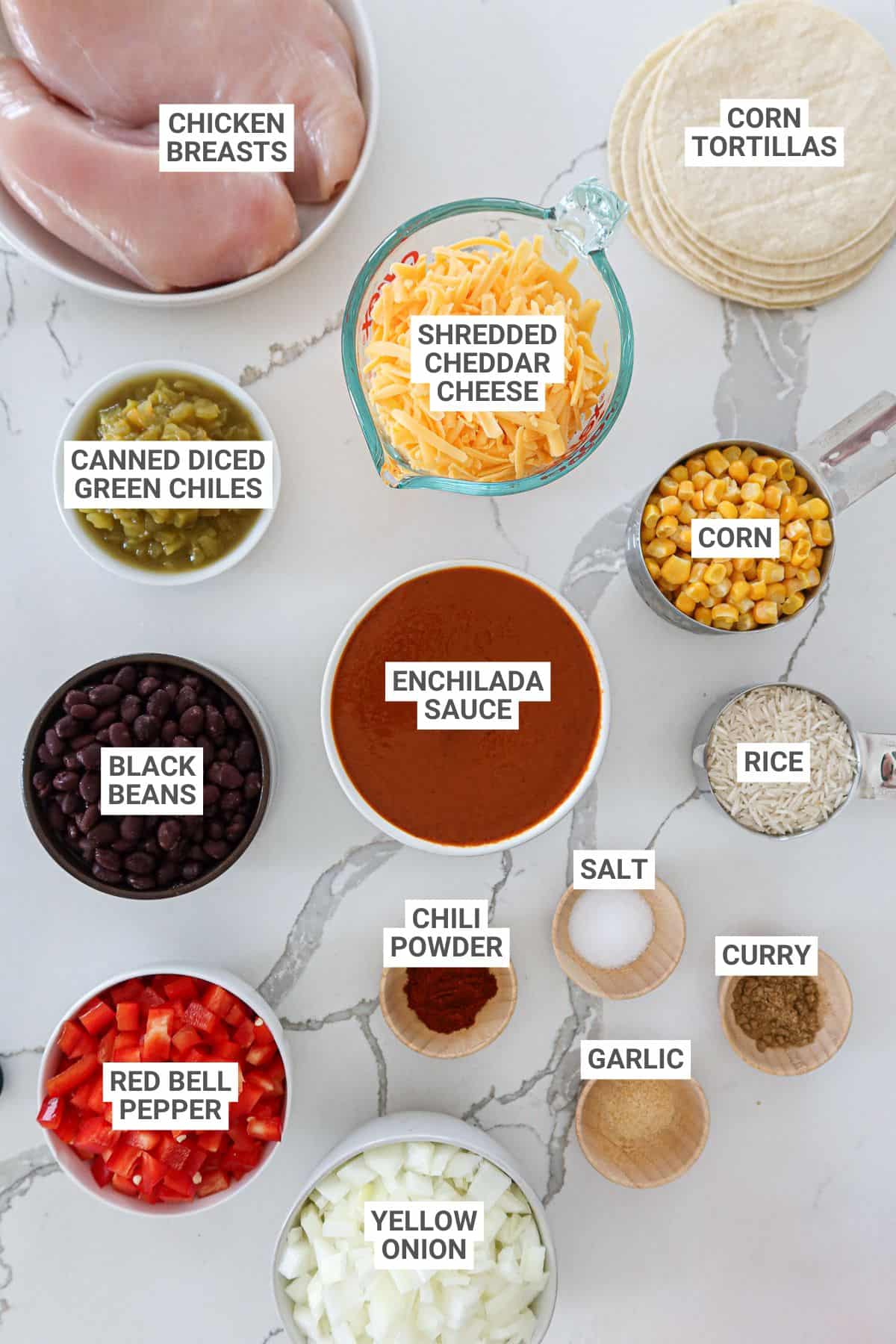 Ingredients for crockpot chicken enchilada casserole on a white countertop with text overlay labels.