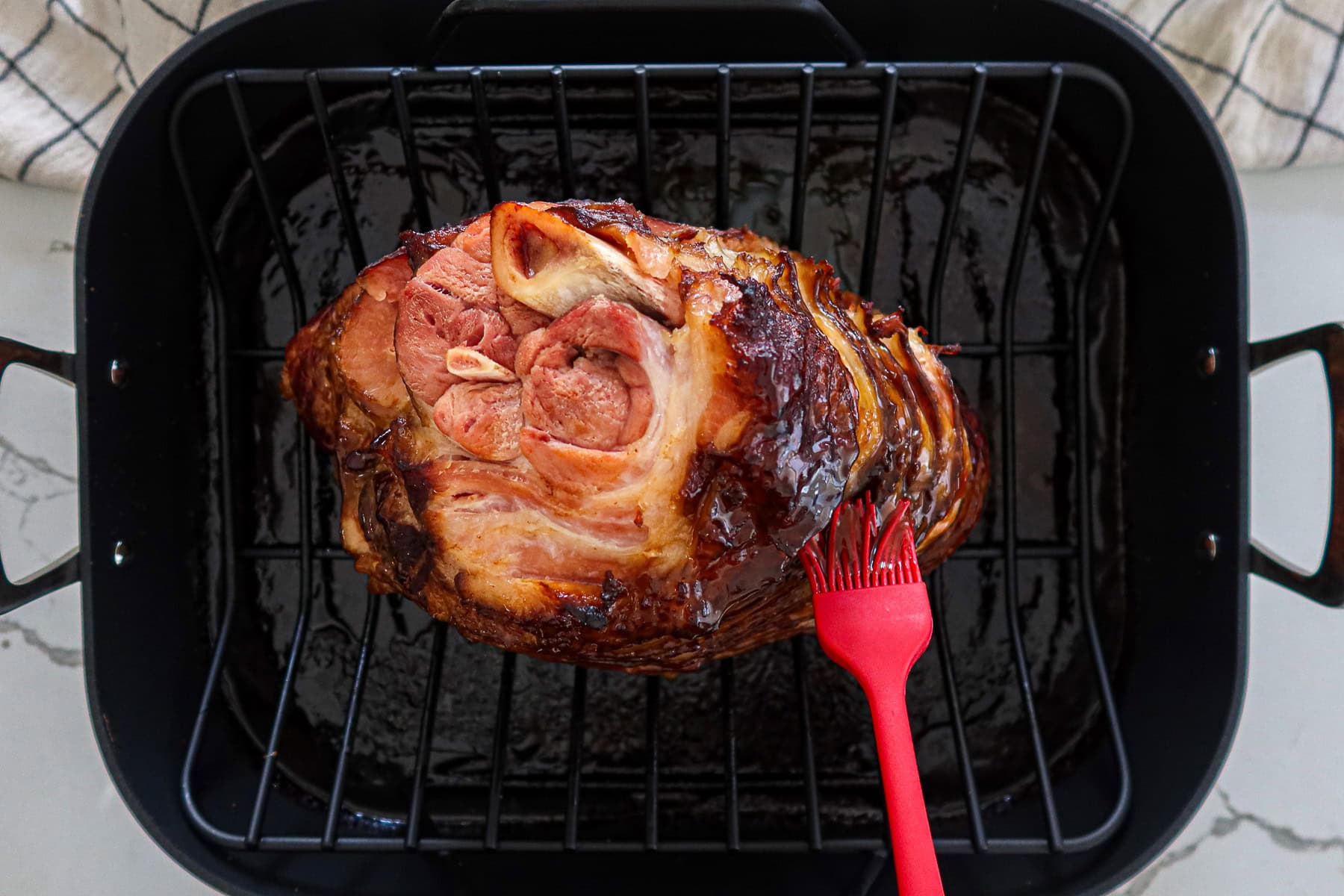Brushing ham with remaining glaze.