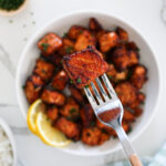 Close up of an air fryer salmon bite on a fork.