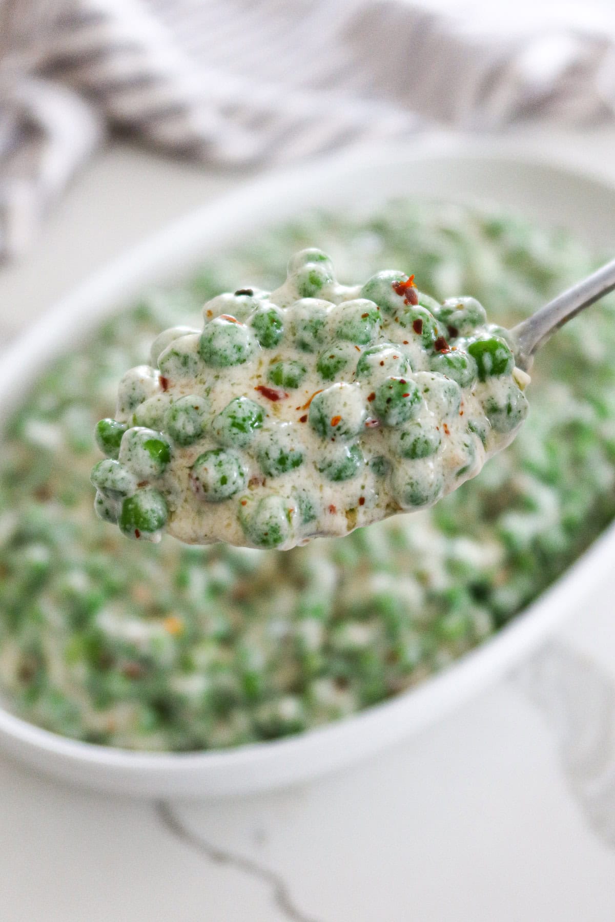 Closeup spoonful of creamed peas.