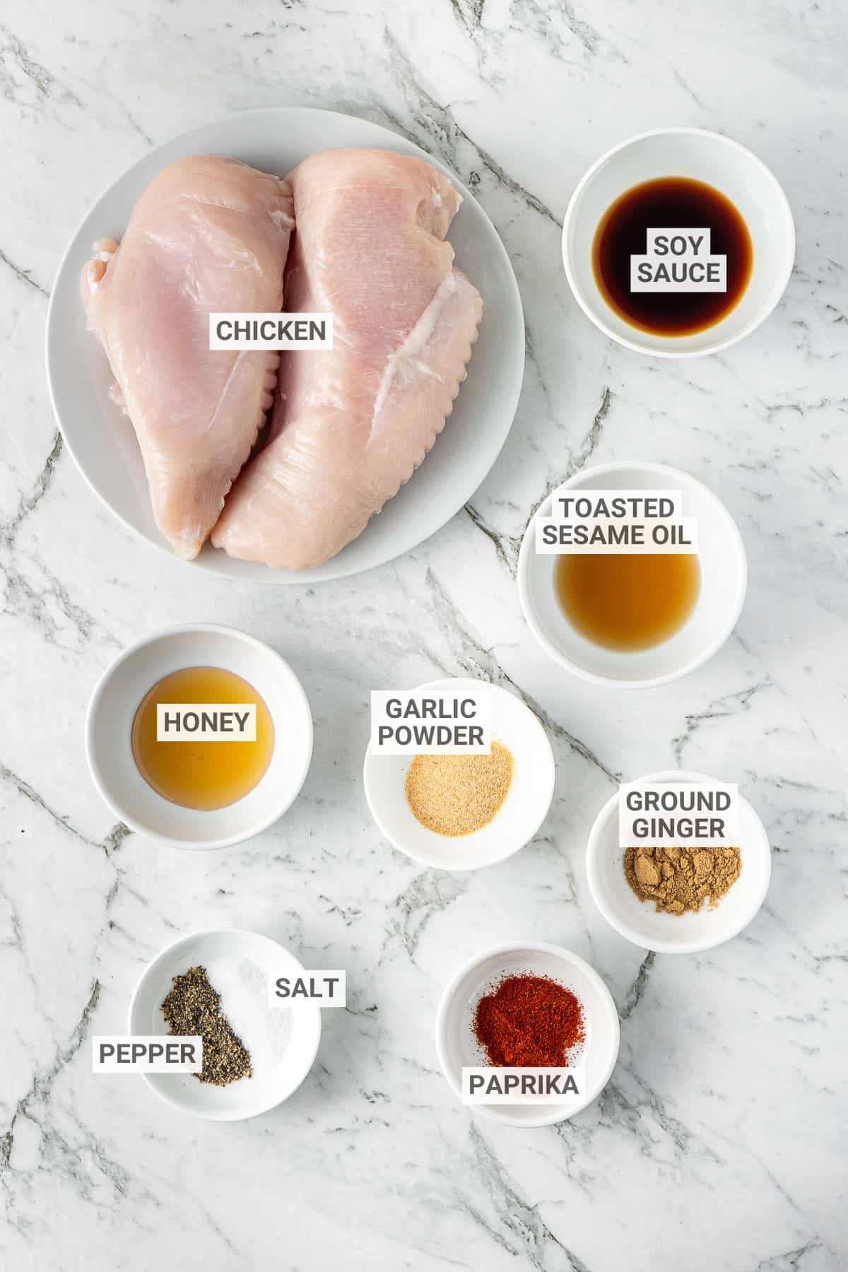 Air fryer chicken bites ingredients on a white marble countertop with text overlay labels.
